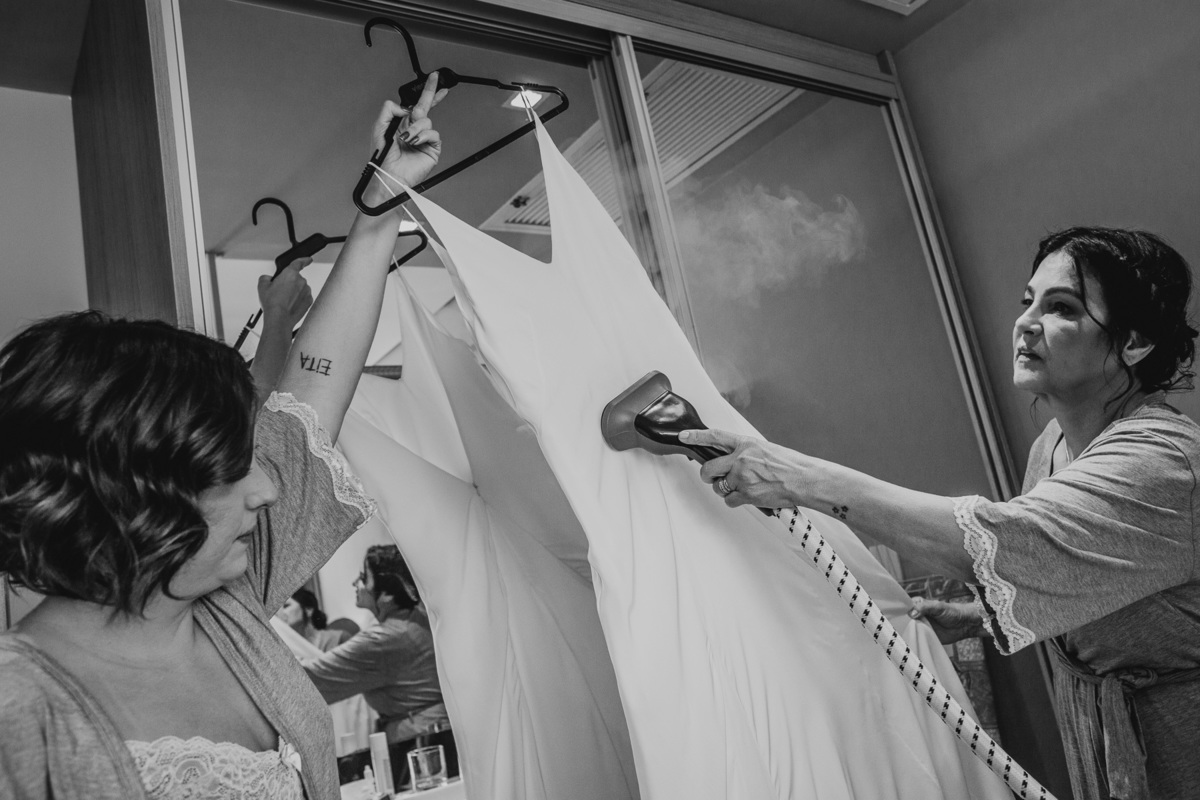 engomando o vestido da noiva no making of. Fotografia de casamento em Recife - PE. Fotógrafo de casamento.