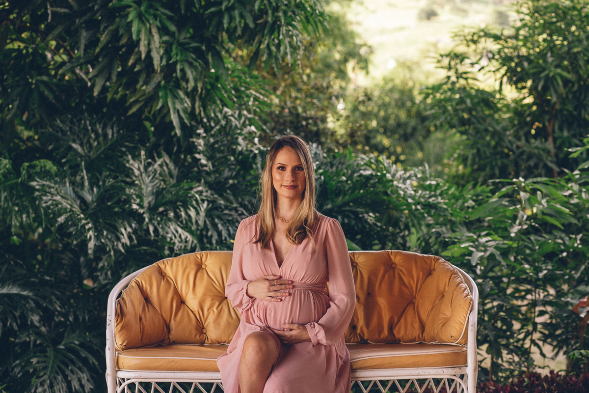 mulher gestante faz pose para fotos numa chácara.