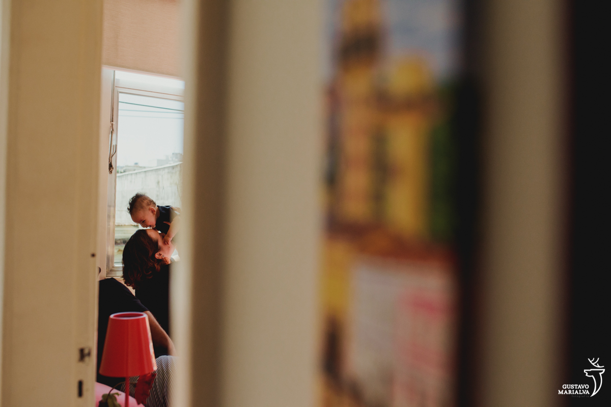 mãe beija o filho e é observada pelo pai