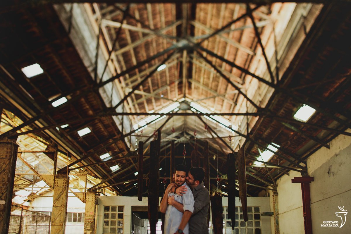 rapaz abraça namorado por trás e dá um beijo em seu pescoço