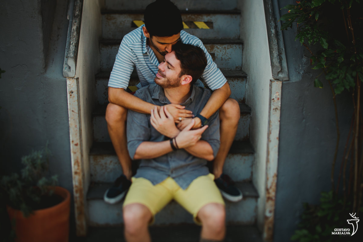 casal gay abraçados e sentados na escada