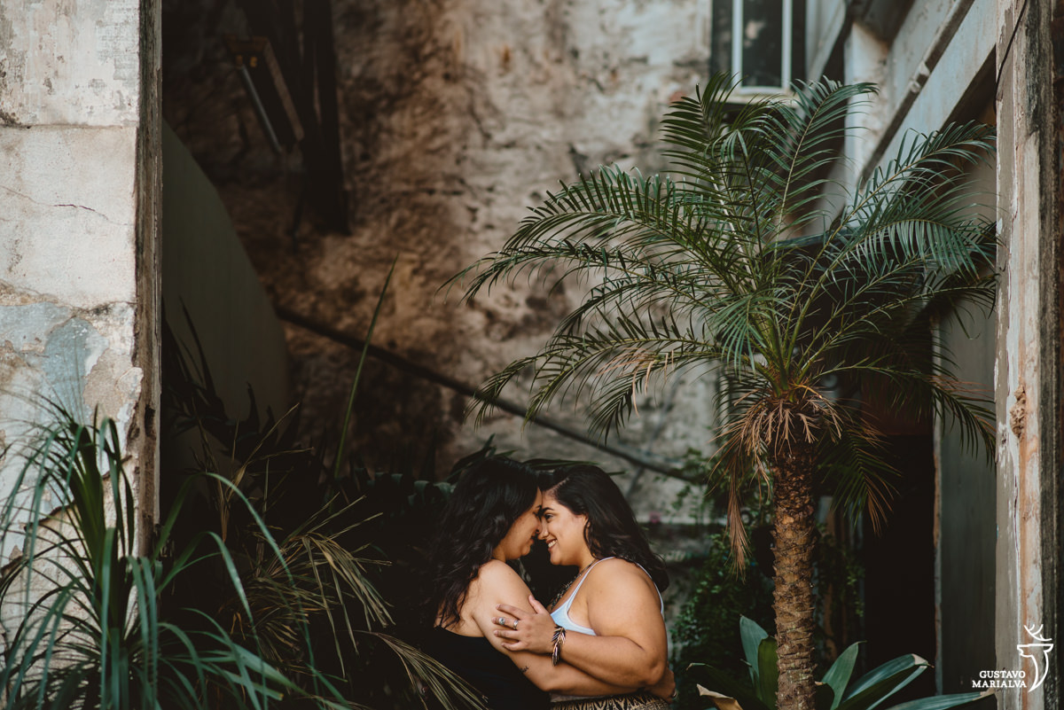 namoradas se abraçam em frente a plantas verdes