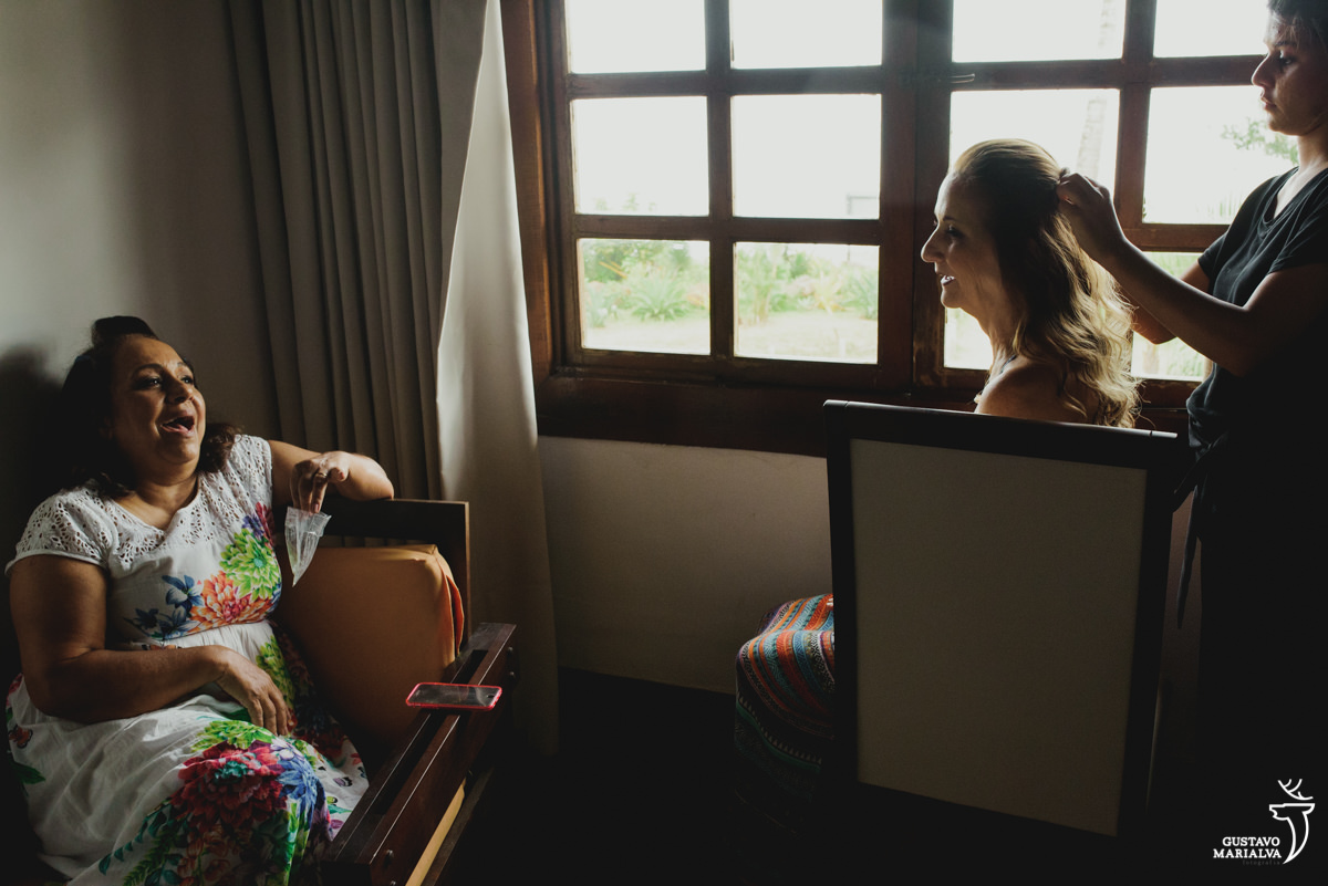 amigas sorriem enquanto uma arruma o cabelo
