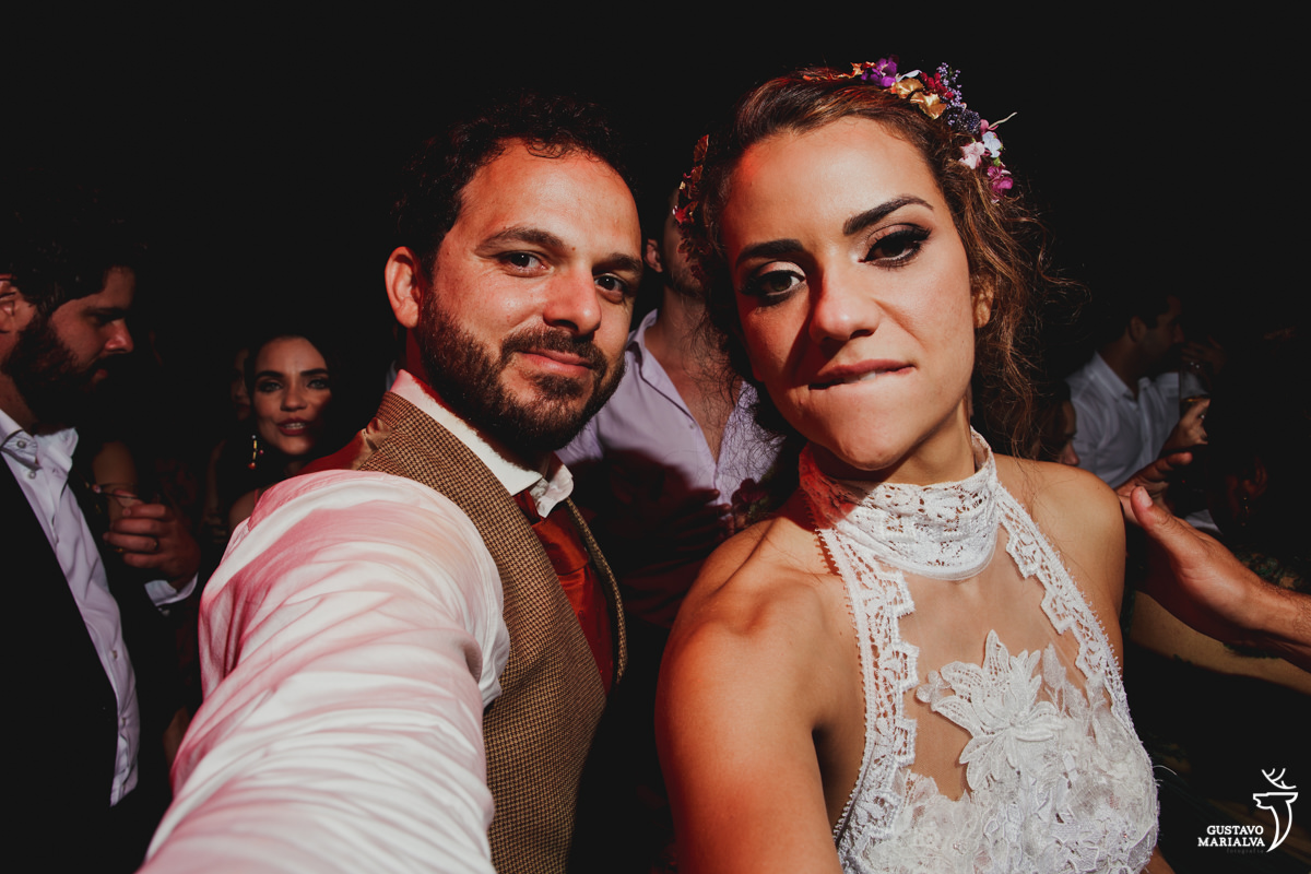 noivos posam olhando para foto enquanto brincam com a barba do fotógrafo