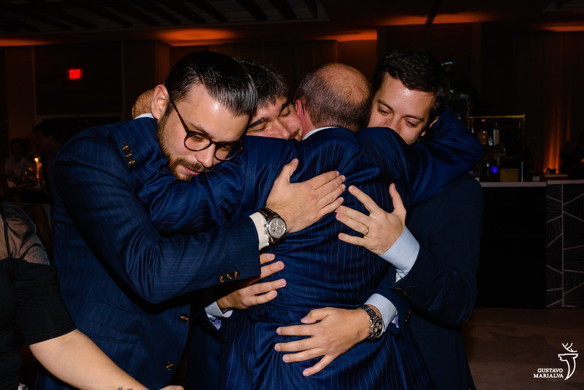 pai abraça os três filhos emocionados