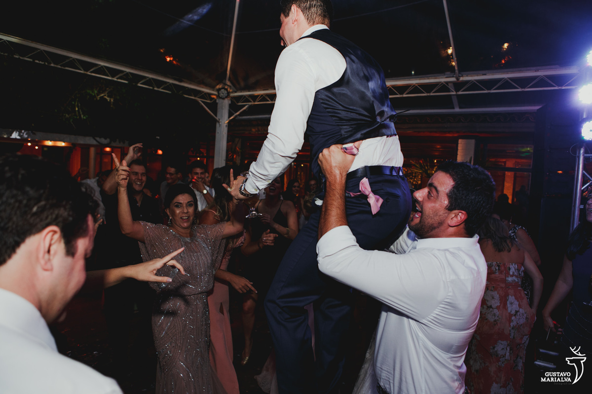 amigo joga o noivo para o alto e sorri