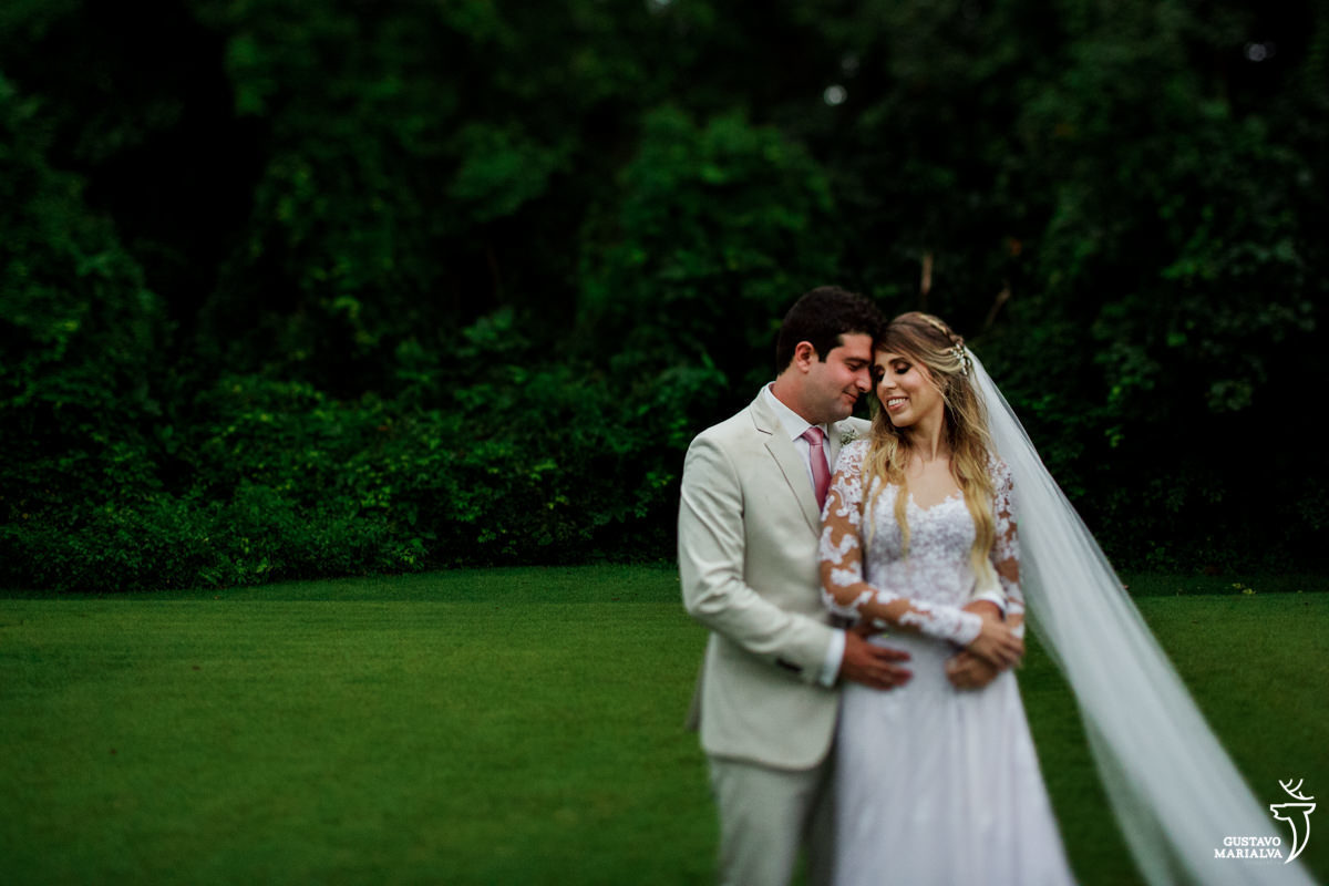 noivo abraça a noiva por trás e sorri