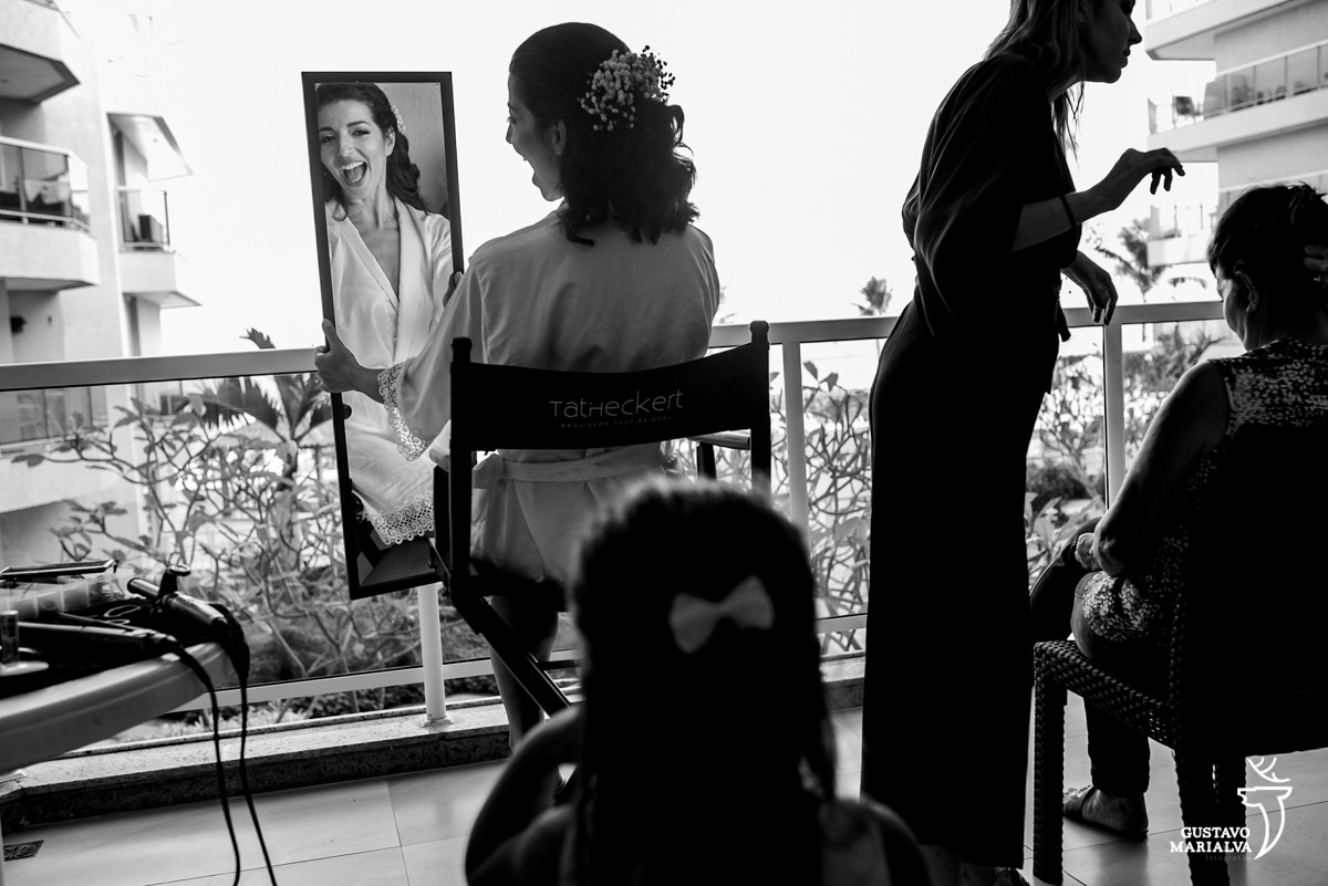 noiva sorri segurando espelho ao ver menina pelo reflexo