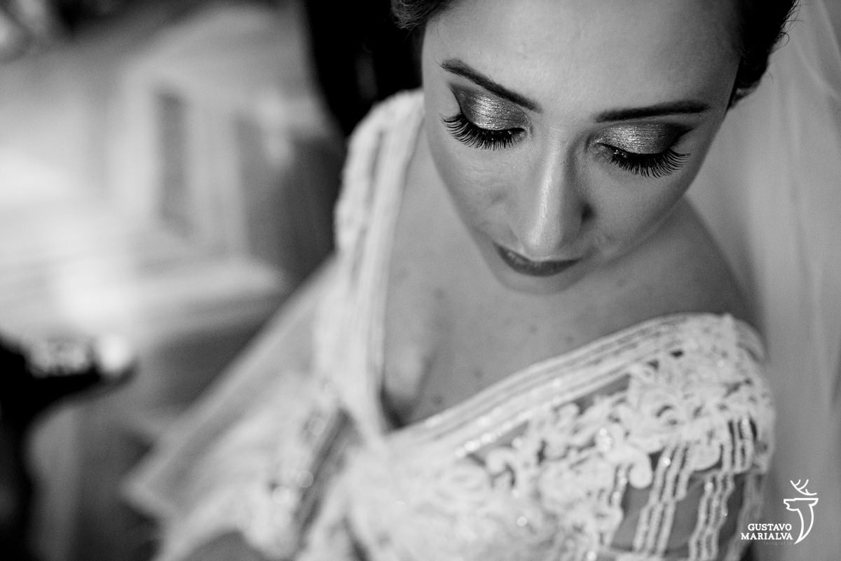 Noiva de olhos fechados mostra a maquiagem e o vestido de noiva