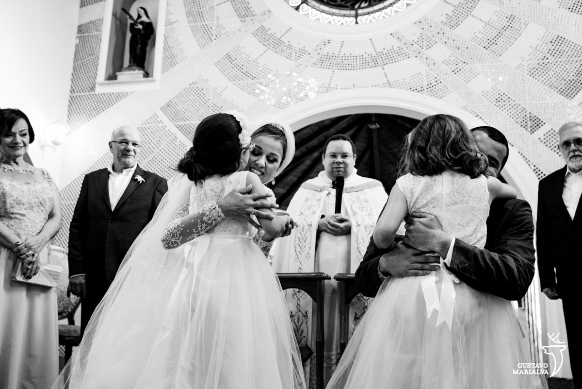 daminhas abraçam os noivos na entrada das alianças