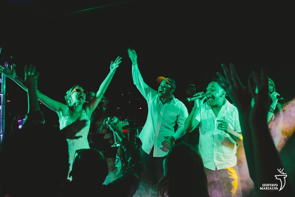 noivos dançam em cima do palco enquanto banda rabuja canta