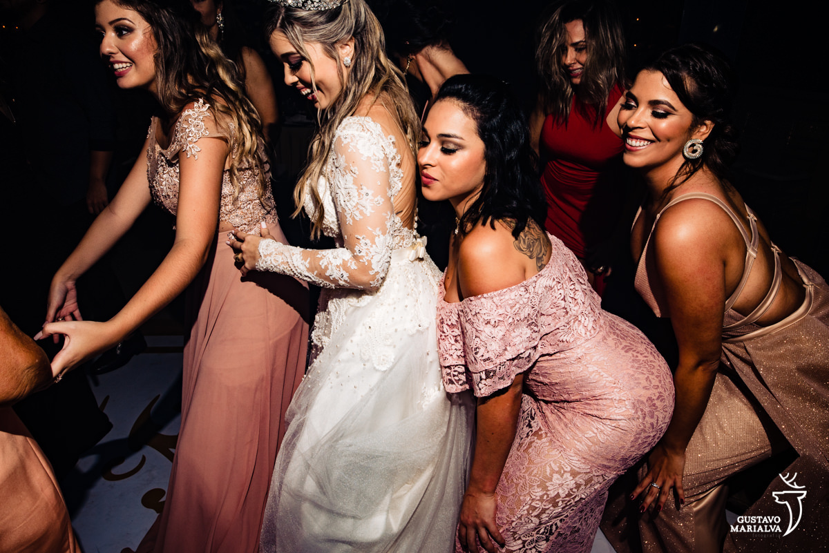 noiva rebola junto a amigas que usam vestido rosa chá