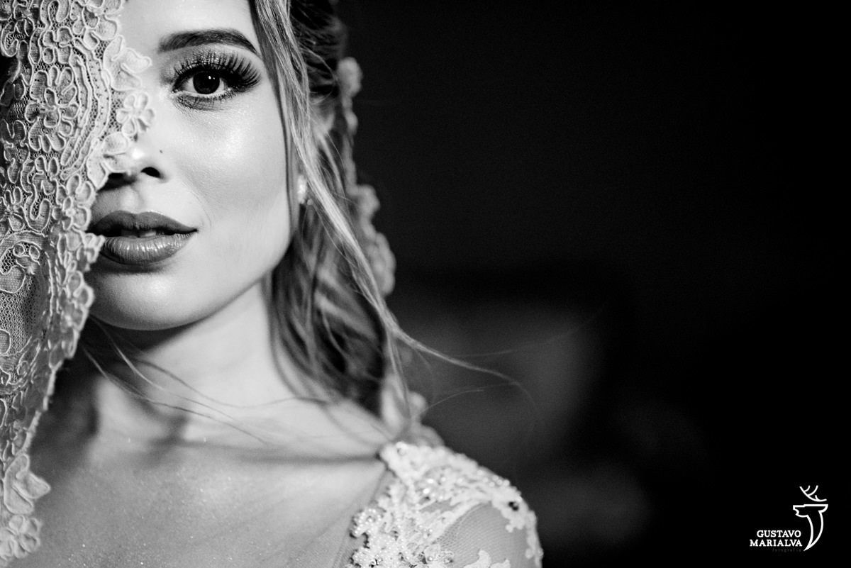 noiva olha para foto com metadade do rosto coberta por véu