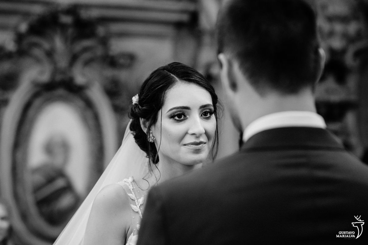 noiva olha emocionada para o noivo durante a troca de votos na cerimônia de casamento