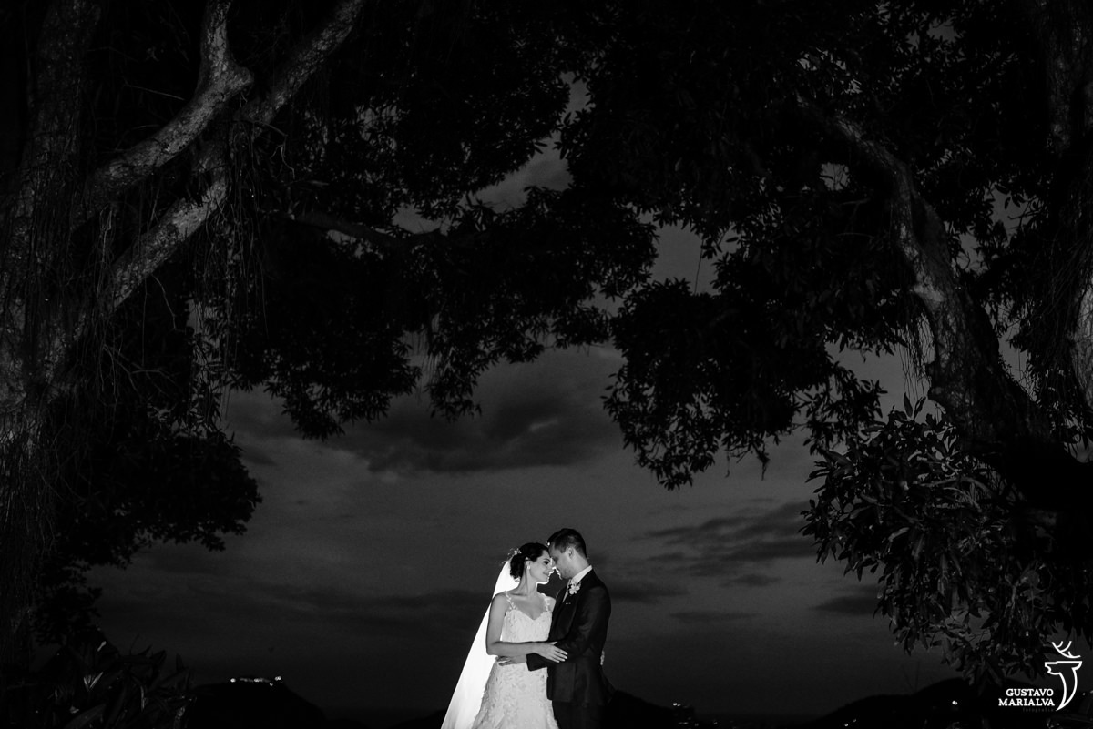 noivos se abraçam com árvores envolvendo o casal