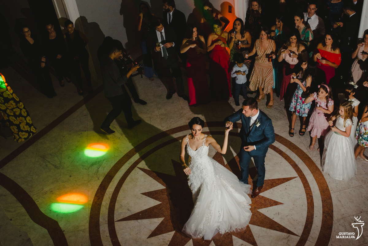 noivos dançam enquanto são observados pelos convidados