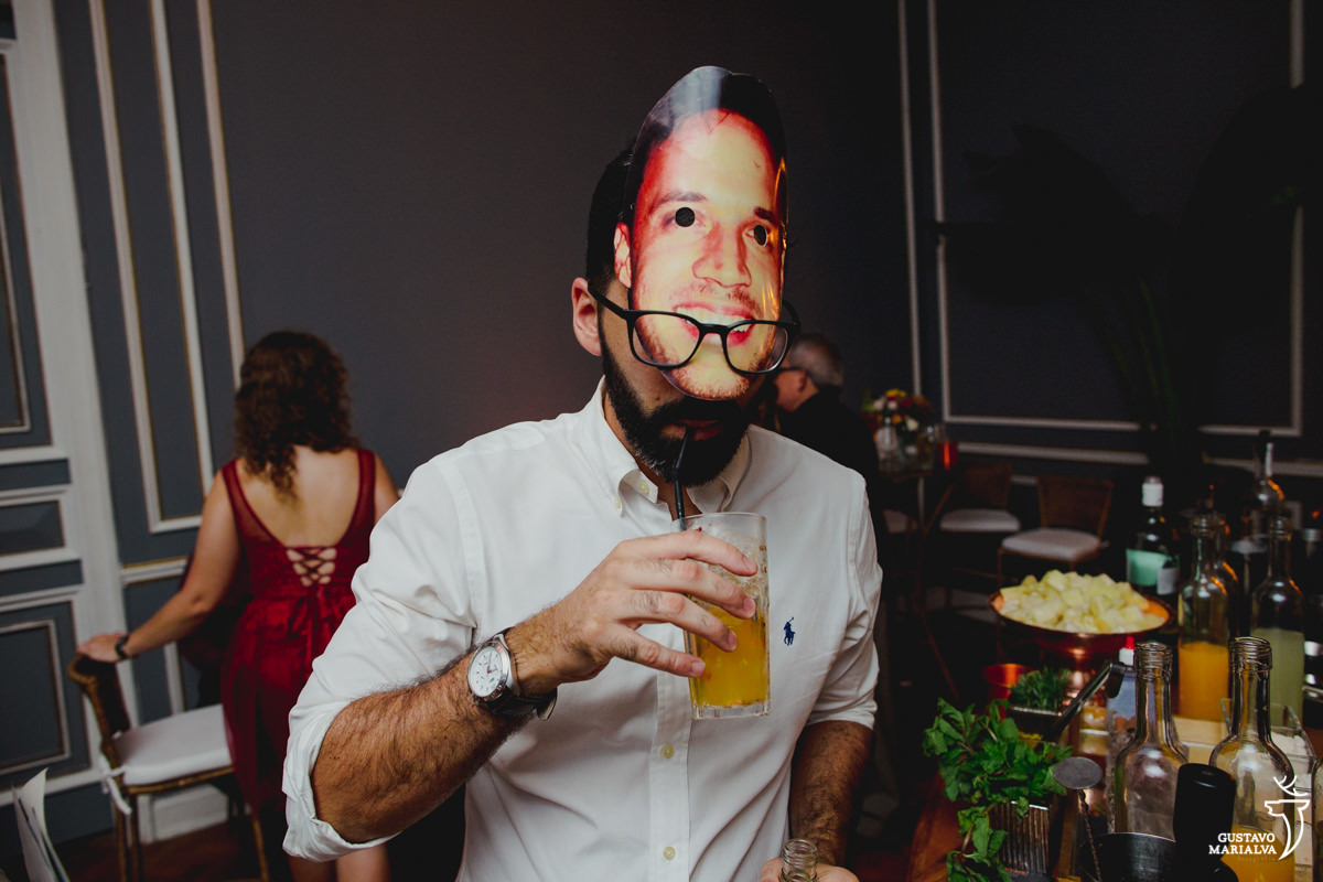 convidado usando máscara toma bebida no canudo