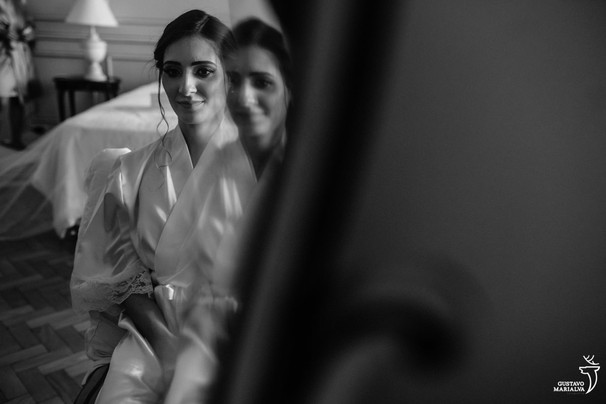 noiva usando rove branco se olha no espelho