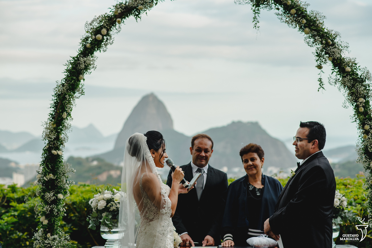 noiva lê os votos para o noivo que sorri com imagem do pão de açúcar ao fundo