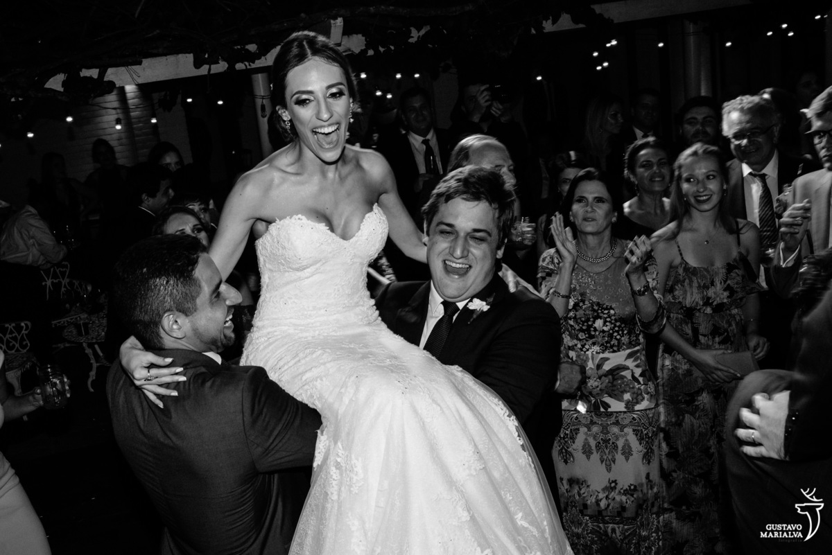 noiva é carregada por amigos e sorri