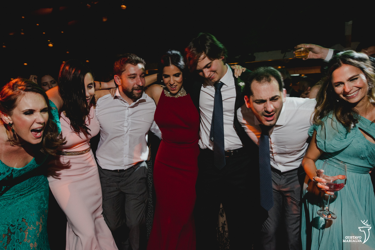 convidados dançam abraçados e sorridentes durante a festa de casamento