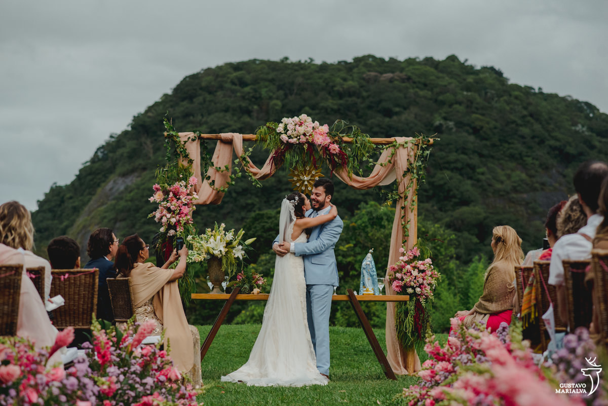 noivos se abraçam e são observados pelos convidados