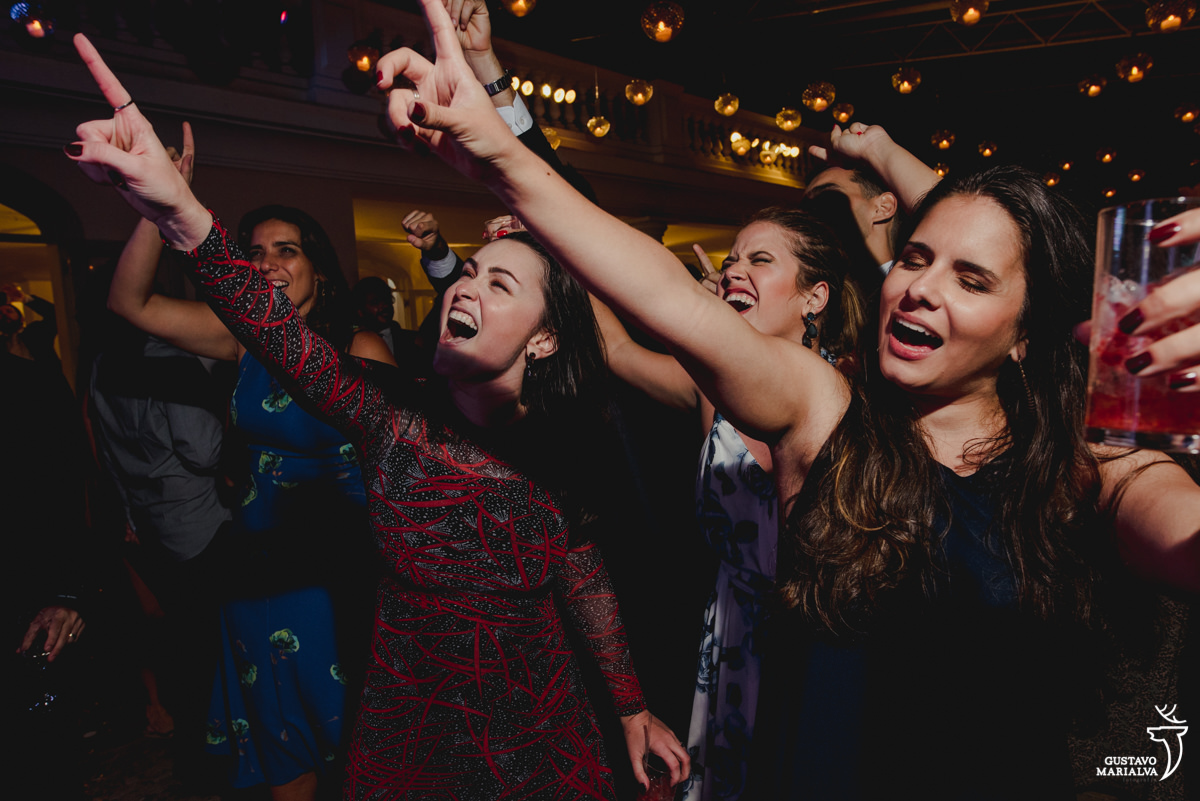 amigas dançam e cantam com os braços para cima