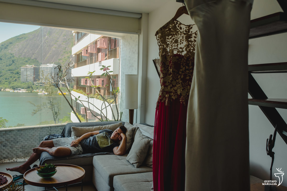homem dorme deitado no sofá com a paisagem da lagoa rodrigo de freitas ao fundo