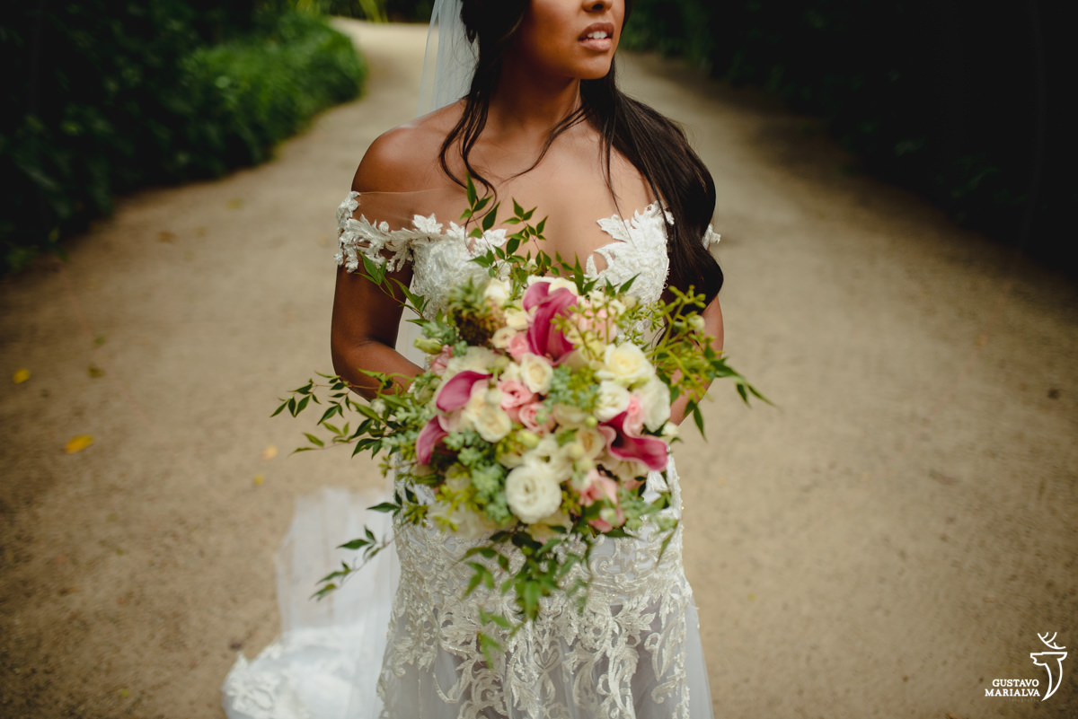 noiva segurando buquê de noiva com flores verdes, rosas e mini abacaxis posa para foto
