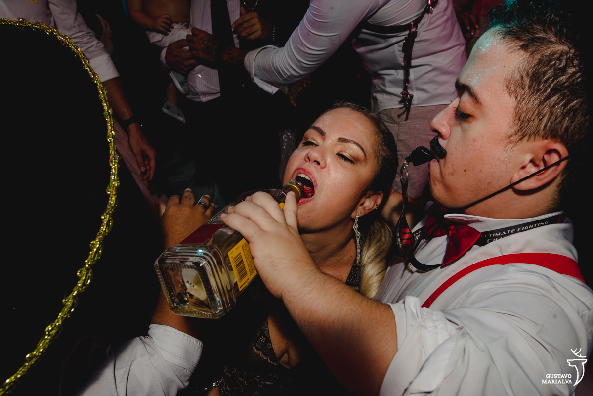 mulher loira toma tequila na festa de casamento