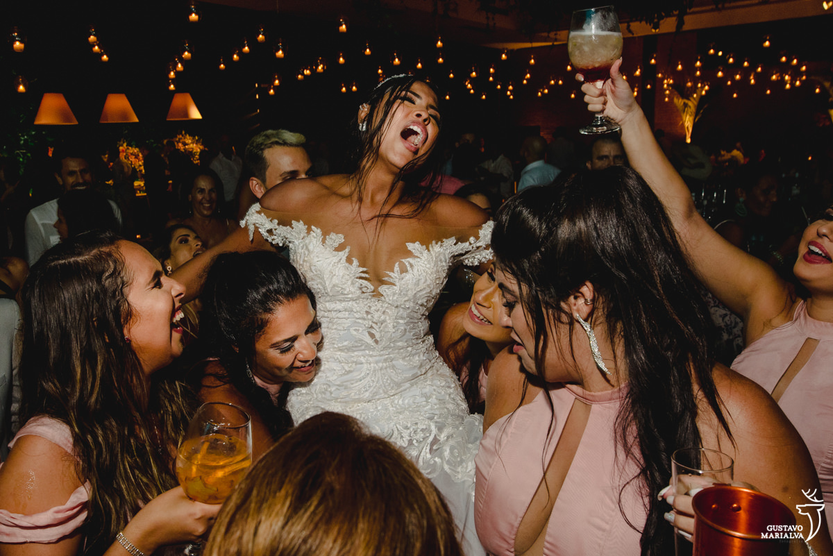 noiva é carregada pelas madrinhas que usam vestido rosa