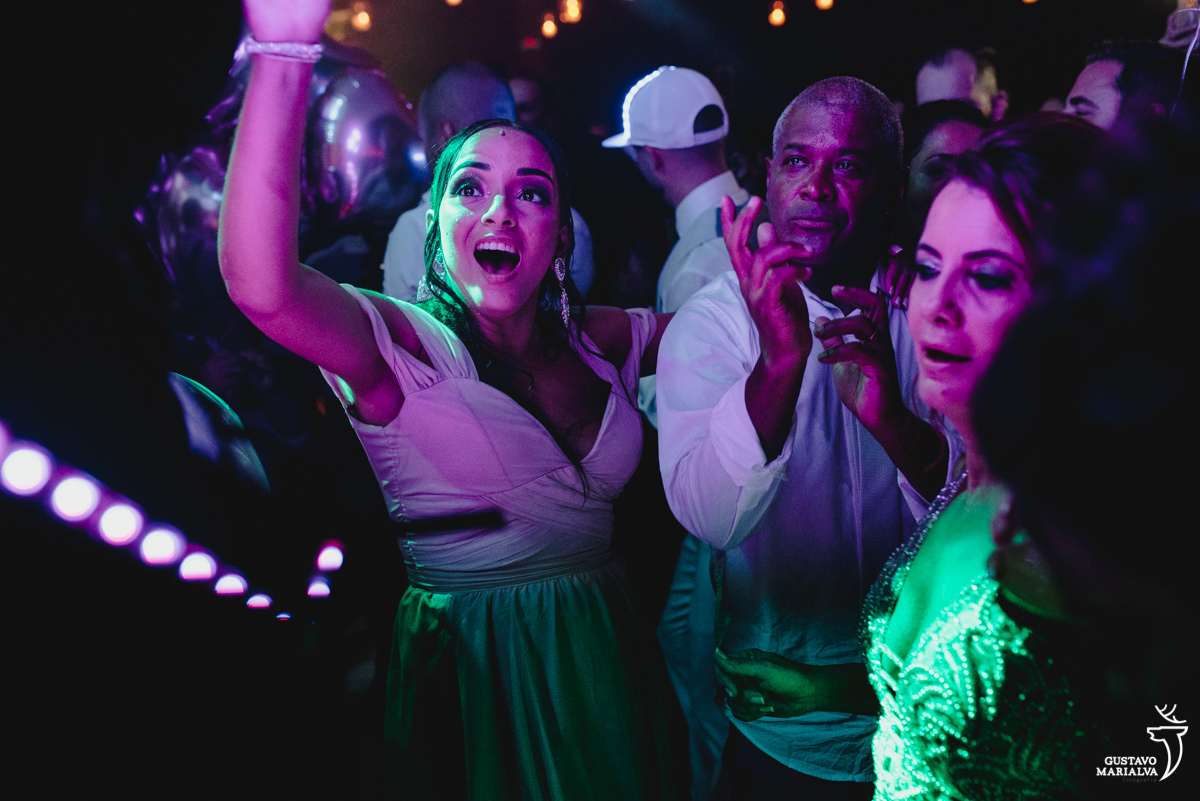 pai da noiva e madrinhas dançam iluminados pela luz roxa