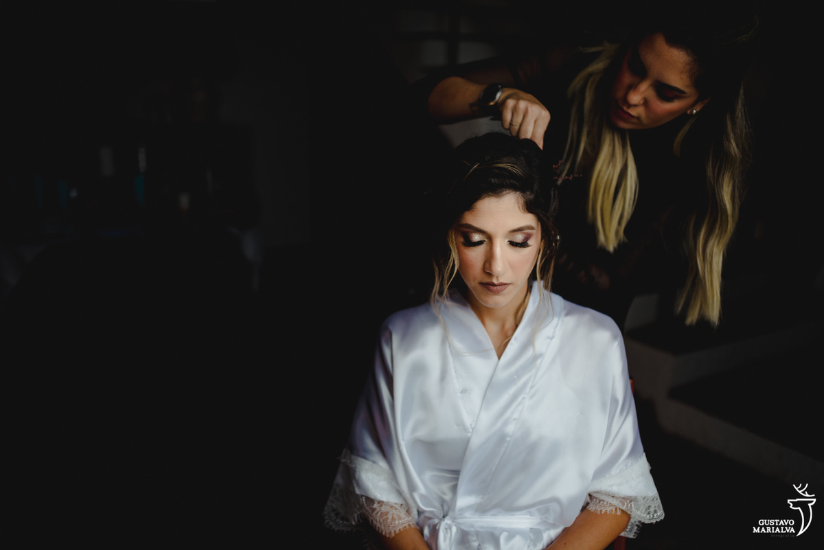 noiva usando robe branco arruma o cabelo