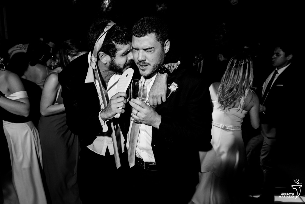 amigos dançam abraçados e fazem chinelo de microfone