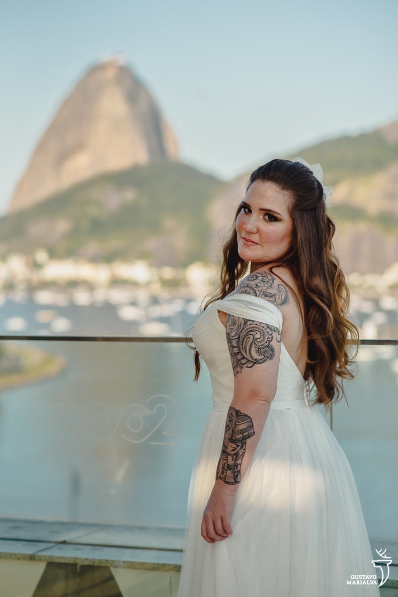 noiva posa para retrato no rooftop do hotel yoo2 rio com vista do pão de açúcar ao fundo