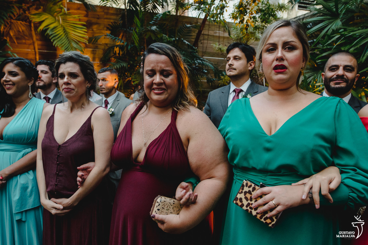 madrinhas usando vestido verde e vinho choram ao ver a noiva entrar
