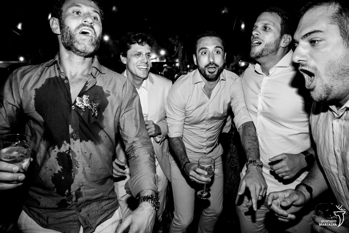 noivo usando camisa azul suada dança com amigos que usam camisa branca