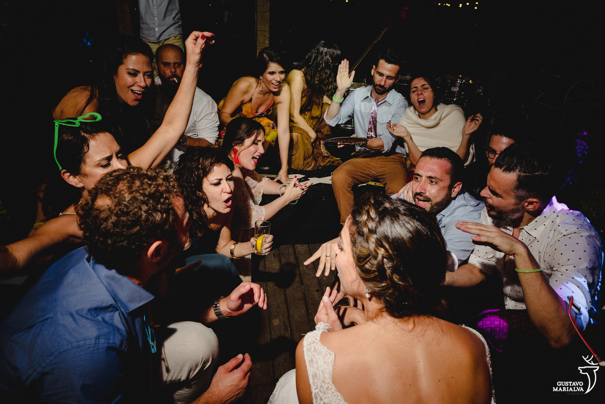 noivos e convidados dançam agachados 