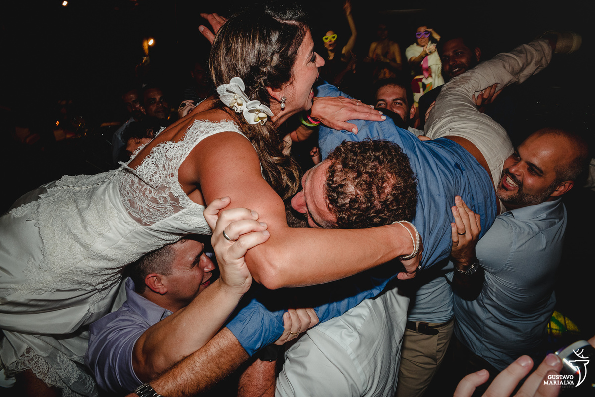 noivos são carregados por amigos que se beijam 