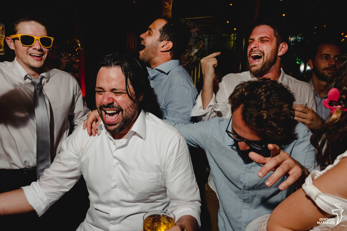 amigos dançam enquanto noiva usa óculos escuro amarelo