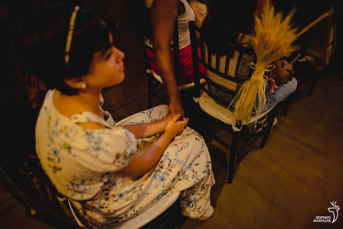 menina usando vestido florido azul e branco segura a mão de amiga
