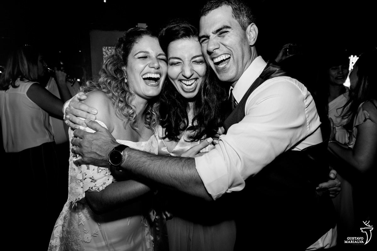 noivos abraçam madrinha durante a festa de casamento 
