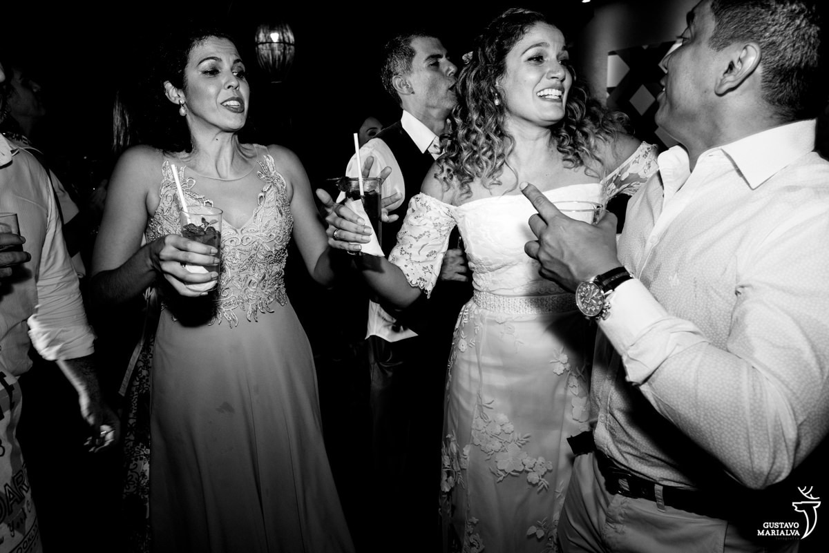 noiva faz careta e dança com convidado de camisa branca enquanto irmã de vestido rosa dança 