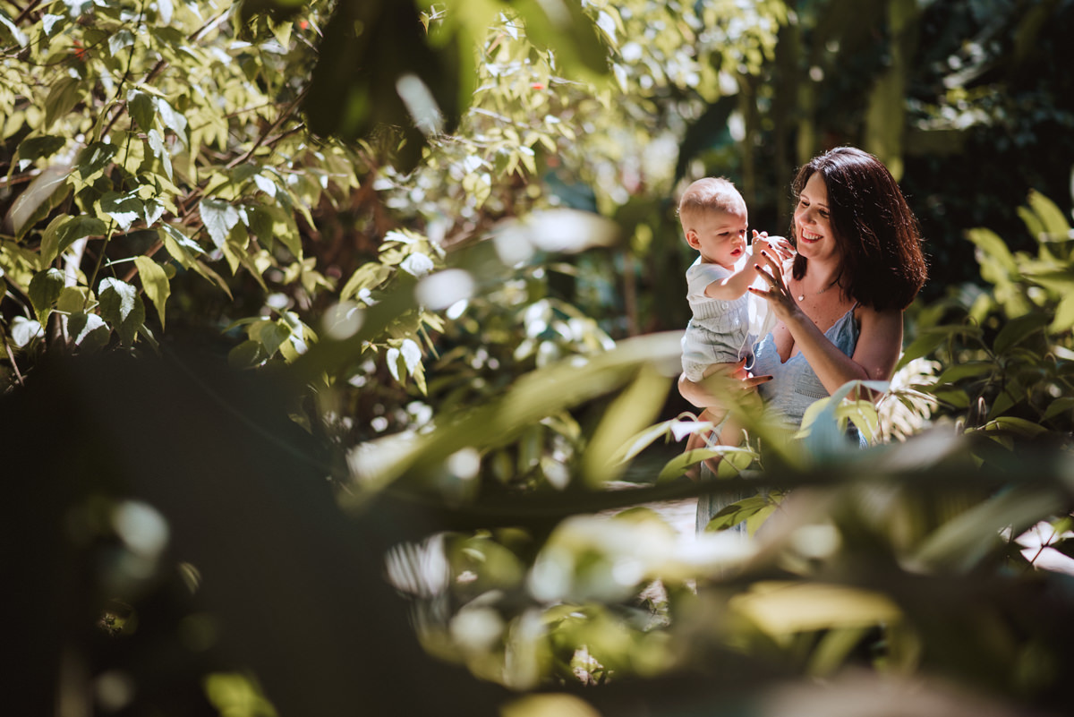 mãe brinca com o filho no meio da mata verde do Parque Lage, no Rio de Janeiro