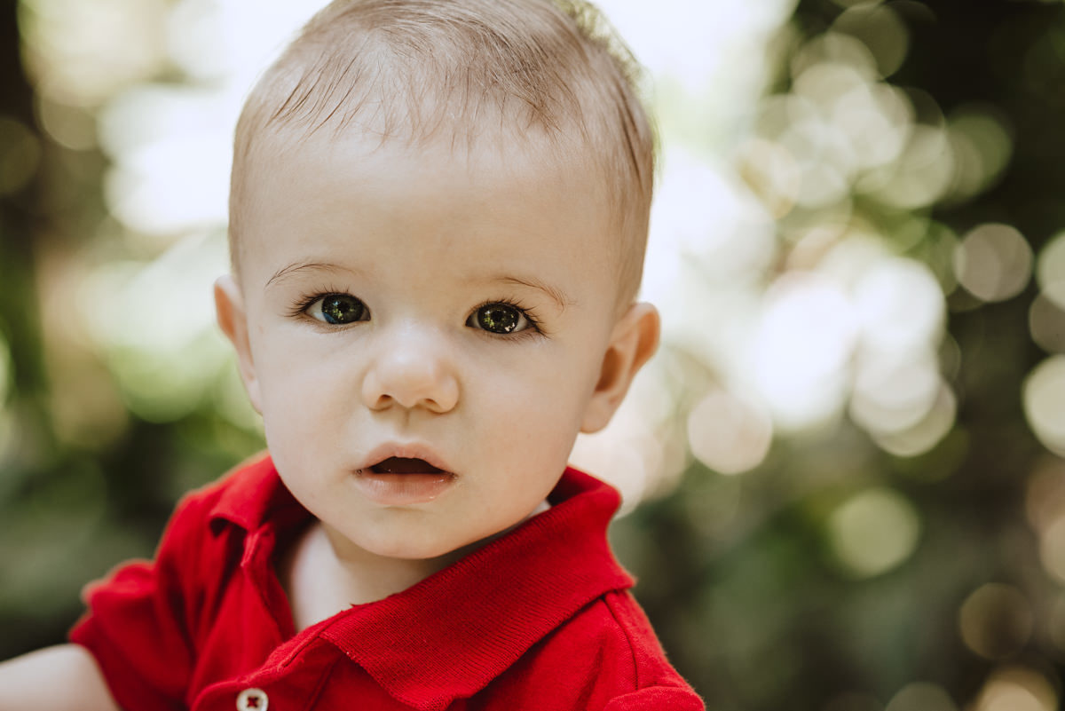 menino usando camisa polo vermelha posa para foto