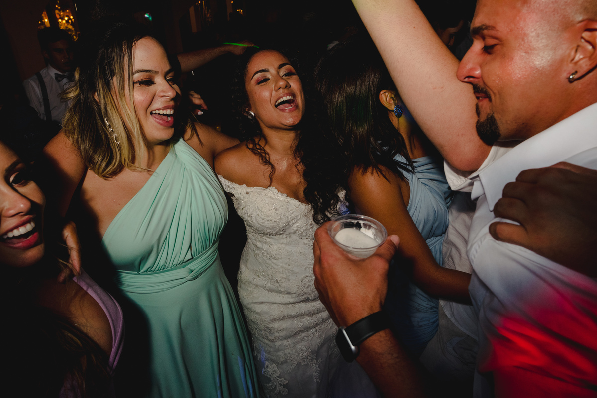 noiva dança abraçada a madrinha de vestido verde