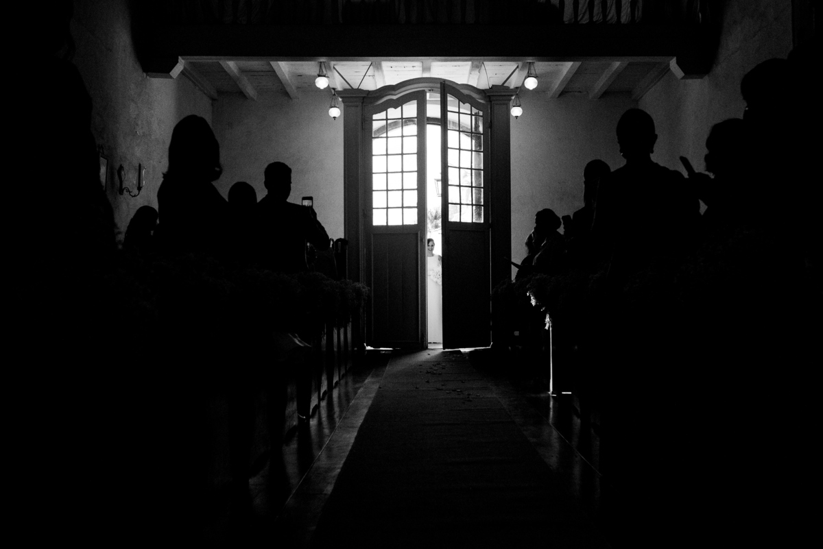 imagem da noiva pela fresta da porta entrando na cerimônia de casamento 