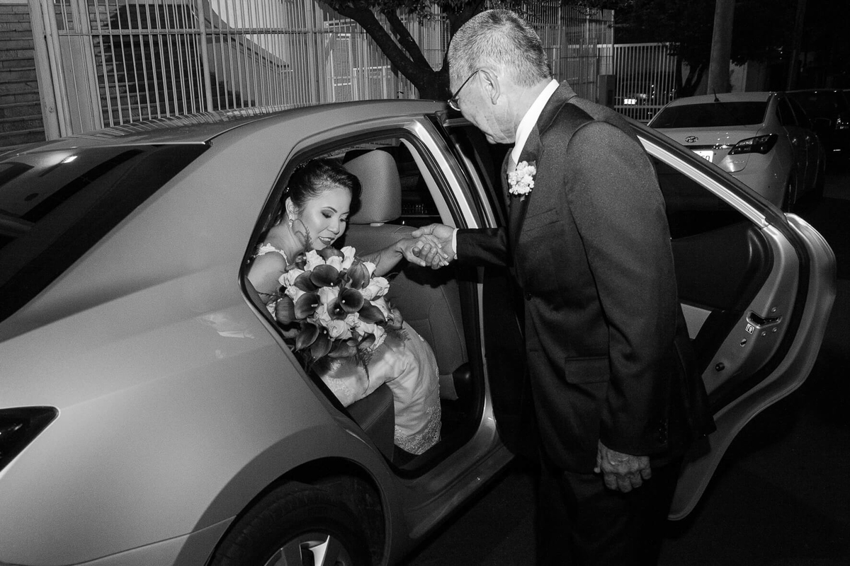 fotografia de noiva saindo do carro ajudada por seu pai 