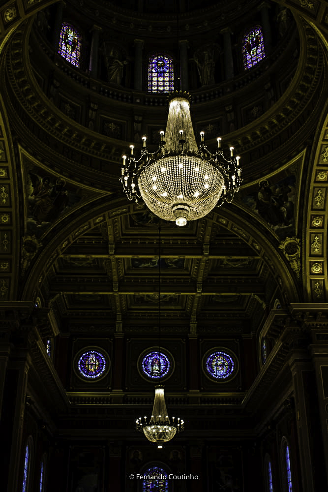 fotografia panoramica da igreja na penumbra destacando o lustre e os vitrais da basilica santo antonio de poadua em americana - sao paulo