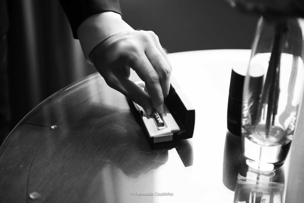 detalhe do noivo pegando a caneta que levara para o casamento religioso onde vai ter o casamento civil na igreja foto esta preto e branco
